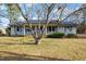 Inviting single-story house with a covered porch, gray siding, and a well-manicured lawn at 245 Cedar Crk Rd, Franklinton, NC 27525