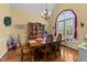 Bright dining room featuring a beautiful chandelier, large window, and elegant wooden furniture at 2490 Earpsboro Rd, Zebulon, NC 27597