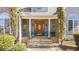Elegant front porch with decorative columns, hanging plants, and a charming seating area at 2490 Earpsboro Rd, Zebulon, NC 27597