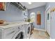 Well-organized laundry room with washer, dryer, and storage shelves at 2490 Earpsboro Rd, Zebulon, NC 27597