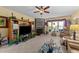 Comfortable living room with a stone fireplace, large windows, and an entertainment center with plants at 2490 Earpsboro Rd, Zebulon, NC 27597
