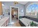 Large tub beneath a beautiful arched window, with a doorway leading to the main bedroom at 2490 Earpsboro Rd, Zebulon, NC 27597