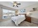 Bright bedroom featuring a queen-size bed, large window, ceiling fan, and neutral decor at 25 Villa Run, Youngsville, NC 27596