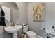 Clean powder room with a pedestal sink, round mirror, and neutral color scheme at 2806 Kempthorne Rd # 62, Cary, NC 27519