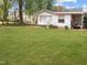 Spacious backyard with lush green grass, garden beds, and a well-maintained exterior of the home at 2836 Oberlin Rd, Raleigh, NC 27608