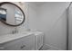 Clean bathroom featuring a modern vanity, round mirror, modern fixtures, and a tiled shower with glass door at 2836 Oberlin Rd, Raleigh, NC 27608