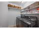 Efficient laundry room with organized shelving and front-loading washer and dryer at 2836 Oberlin Rd, Raleigh, NC 27608