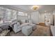 Bright living room with large windows, a comfortable white sofa, stylish ottomans and an decorative area rug at 2836 Oberlin Rd, Raleigh, NC 27608