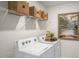 Well-organized laundry room featuring a white washer and dryer and decorative woven basket storage above at 314 Umstead St, Sanford, NC 27330