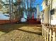 Spacious backyard featuring a red-stained wood deck, mature trees, a shed, and a well-maintained lawn for outdoor enjoyment at 401 Maymount Dr, Durham, NC 27703