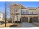Charming two-story townhome with a stone and siding exterior, two car garage, and well maintained landscaping at 415 Mariah Towns Way, Garner, NC 27529