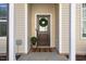 Charming front door with wreath, dark door, neutral siding, decorative plants, and white trim at 415 Mariah Towns Way, Garner, NC 27529