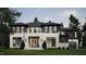 Stunning modern home with a light brick and stone exterior, black trim windows, lush lawn, and professional landscaping at 4308 Windsor Pl, Raleigh, NC 27609