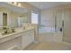 Bright bathroom featuring a double sink vanity, soaking tub, and glass enclosed shower at 5008 Casland Dr, Raleigh, NC 27604