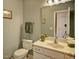 Neutral-toned bathroom with a white toilet and vanity, a mirrored medicine cabinet and a towel bar at 5008 Casland Dr, Raleigh, NC 27604