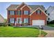 Traditional two-story brick home featuring a well-manicured lawn and attached two car garage at 5008 Casland Dr, Raleigh, NC 27604