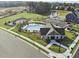 Enjoy this aerial view of the community pool, playground, and amenity center with pond and construction nearby at 504 Lemon Daisy Ln, Knightdale, NC 27545
