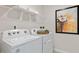 Laundry room featuring modern appliances, decorative shelving, and stylish art at 515 Old Battle Bridge Rd, Wendell, NC 27591