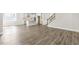 Open-concept living space with hardwood floors, staircase, and kitchen in the background at 528 Lemon Daisy Ln, Knightdale, NC 27545