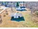 Charming aerial view of white homes, outbuilding, and spacious yard with mature trees, exuding Southern charm at 57 Lowell Ct, Smithfield, NC 27577