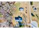 Aerial view of gray roof, yard with mature trees, surrounding homes, and paved road at 57 Lowell Ct, Smithfield, NC 27577