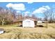 The exterior features white siding, two overhead doors, covered storage, and mature trees at 57 Lowell Ct, Smithfield, NC 27577