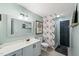 Bright bathroom with a single sink vanity, decorative wall paper, a framed mirror, and a glass-enclosed shower at 614 Capital Blvd # 229, Raleigh, NC 27603
