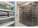 Modern bathroom showcasing a glass shower with dark subway tile and floating shelves stocked with fresh towels at 614 Capital Blvd # 229, Raleigh, NC 27603