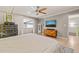 Bright bedroom featuring a ceiling fan, mountain-scene TV, dresser, and view to another living space at 614 Capital Blvd # 229, Raleigh, NC 27603
