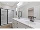 A full bathroom features a double sink vanity, large mirror and a tiled shower with black trim at 704 East St, Smithfield, NC 27577