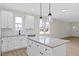 Bright kitchen features white cabinetry, granite countertops, stainless steel appliances, and modern pendant lighting at 704 East St, Smithfield, NC 27577