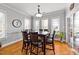 Bright dining room featuring a wooden table set, natural light from windows, and hardwood floors at 101 Mantle Dr, Clayton, NC 27527