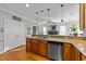 A spacious kitchen with stainless steel appliances, wooden cabinets, and a view to the living area at 101 Mantle Dr, Clayton, NC 27527