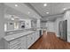 Kitchenette features stainless appliances, white cabinets, granite counters, hardwood flooring, and recessed lights at 101 Mantle Dr, Clayton, NC 27527