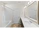 Bright bathroom with double sinks, a large vanity mirror, and shower-tub combo at 115 Dolomite Dr, Gibsonville, NC 27249