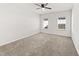 Spacious bedroom with plush carpeting and two windows providing plenty of natural light at 115 Dolomite Dr, Gibsonville, NC 27249