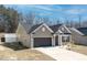 Low angle showing the side of this single story home with attached two car garage at 115 Dolomite Dr, Gibsonville, NC 27249