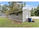 Side exterior showcasing the home's green siding, concrete foundation, and tidy backyard at 1213 Freeman Dr, Sanford, NC 27330
