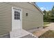 A white exterior door on a green home with updated lighting at 1213 Freeman Dr, Sanford, NC 27330