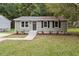Charming single-story home with green siding, black shutters, and a well-manicured lawn at 1213 Freeman Dr, Sanford, NC 27330