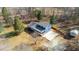 Aerial shot of a blue house with grey roof, a porch and a concrete patio surrounded by trees at 12507 N Roxboro St, Rougemont, NC 27572