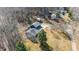 Aerial view of a charming blue house with a porch, an expansive yard, and surrounding trees at 12507 N Roxboro St, Rougemont, NC 27572