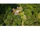 Aerial view of a property nestled among lush trees and showcasing its house and surroundings at 12507 N Roxboro St, Rougemont, NC 27572