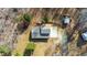 An aerial view of a gray-roofed house featuring a patio area, outbuildings, and a yard at 12507 N Roxboro St, Rougemont, NC 27572