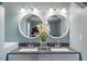 Bathroom with dual sinks, granite countertops, and round mirrors at 12507 N Roxboro St, Rougemont, NC 27572