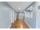 Hallway with wood-look flooring and light blue-grey walls, with doorways and cut-out at 12507 N Roxboro St, Rougemont, NC 27572