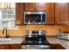 Close up of kitchen with stainless steel appliances, dark countertops, and wooden cabinetry at 12507 N Roxboro St, Rougemont, NC 27572