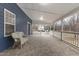 Spacious covered porch featuring stone-look tile flooring and a cozy wicker chair at 12507 N Roxboro St, Rougemont, NC 27572