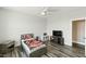 Charming bedroom featuring a ceiling fan, television, and stylish gray wood flooring at 158 Futrell Ridge Ct, Chapel Hill, NC 27517