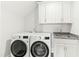 Bright laundry room with a white washer and dryer, cabinets, and sink at 158 Futrell Ridge Ct, Chapel Hill, NC 27517